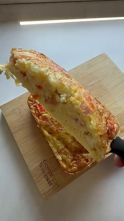 Aufgeschnittenes Bauernomelett aus dem Airfryer mit Paprika, Zwiebel, Schinken und geschmolzenem Käse
