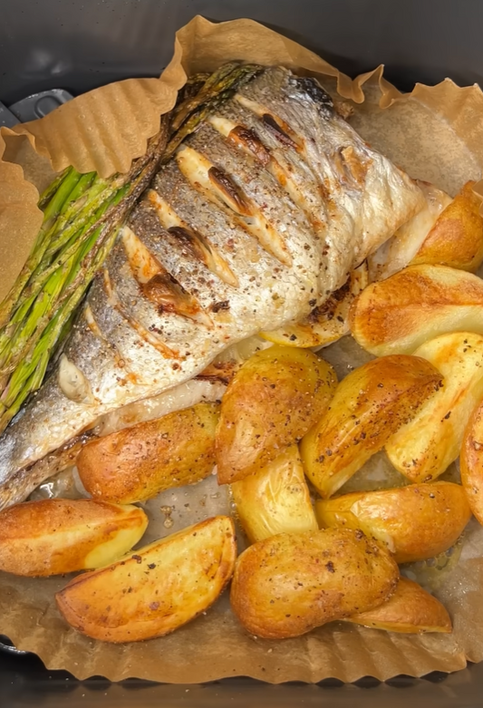 Dorade mit goldbraunen Kartoffelspalten und grünem Spargel aus dem Airfryer