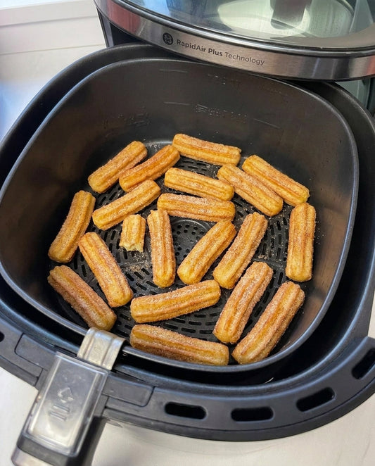 Goldbraune Churros mit Zimtzucker in einem offenen Airfryer-Korb