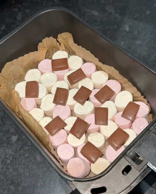 Marshmallows mit Milchschokolade in einem mit Backpapier ausgelegten Airfryer-Korb