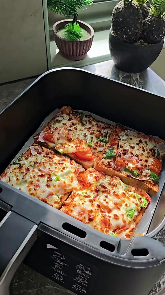 Vier goldbraun gebackene Brotpizzen mit Mozzarella, Paprika, Tomate und roter Zwiebel im Airfryer