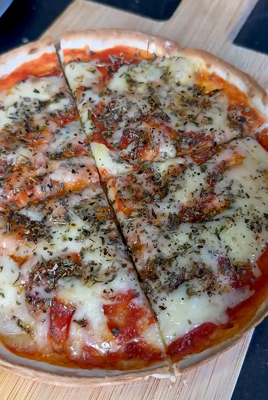 Gebackene Wrap-Pizza mit Tomatensoße, geschmolzenem Käse und italienischen Kräutern, in Stücke geschnitten